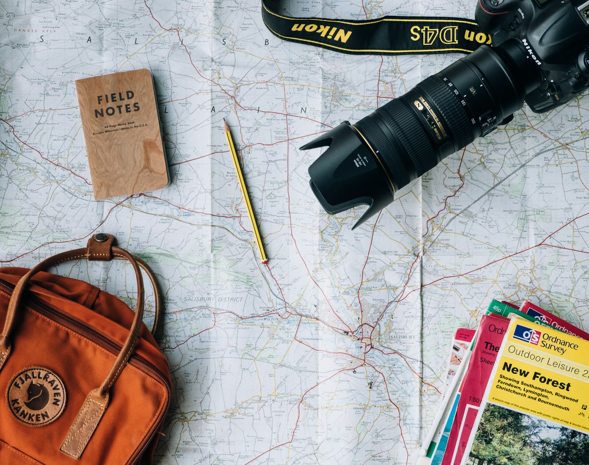 Flat lay of map, camera and travel items on a desk